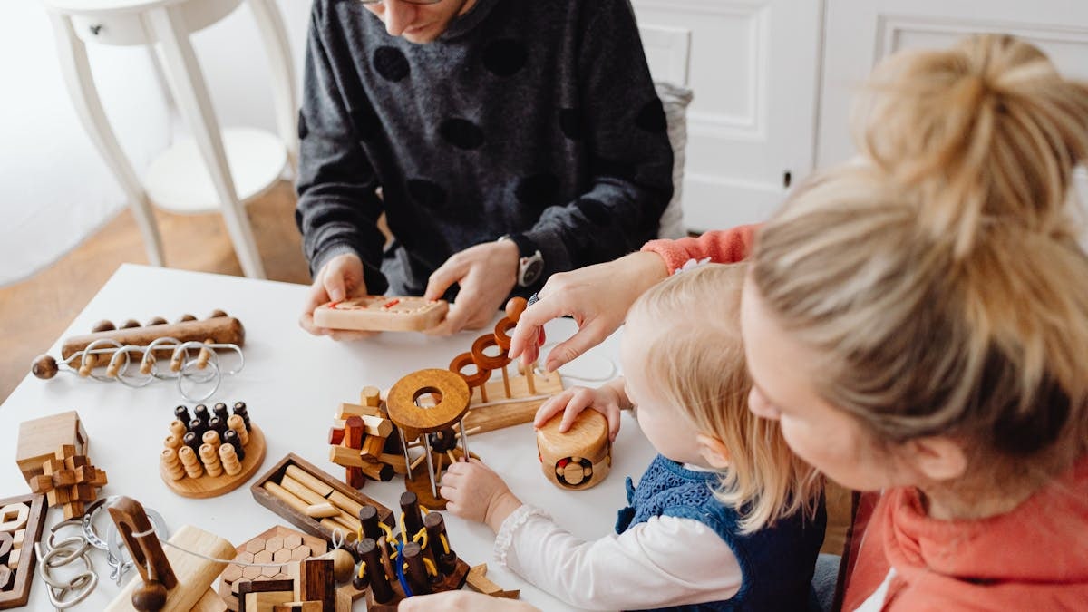A family playing with wooden educational toys, enjoying quality time indoors.