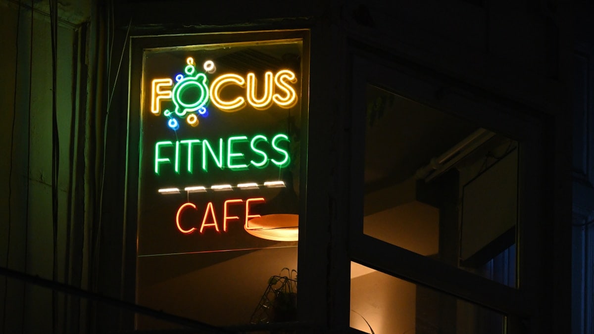 A focus fitness cafe sign lit up at night
